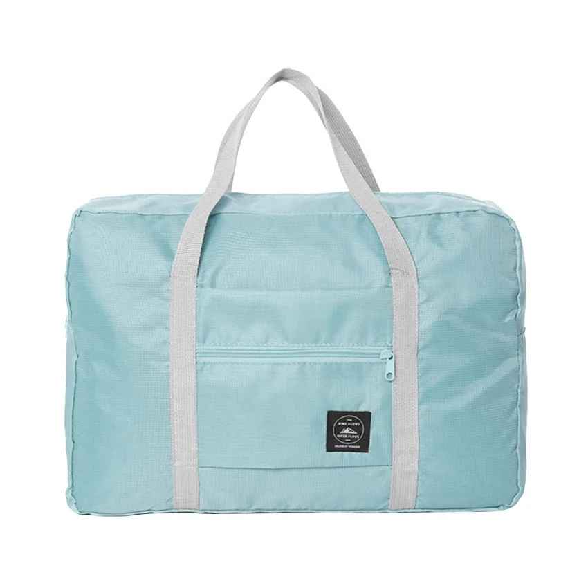 Blue foldable travel duffel bag with carry handles and front zip pocket.
