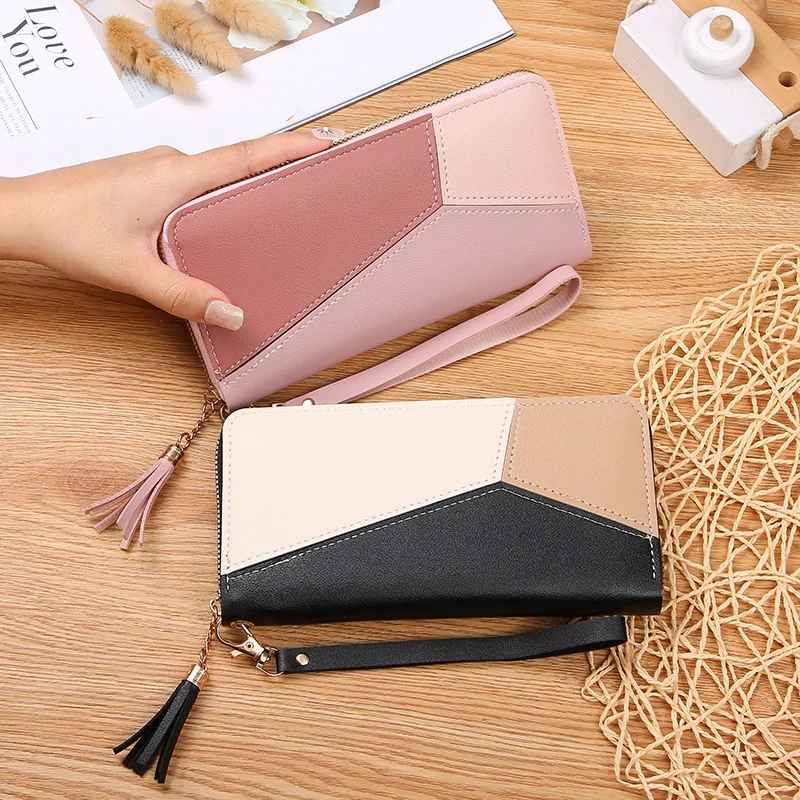Women's patchwork zip wallet in black and pink in hand